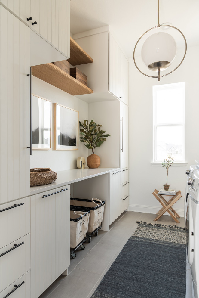 Design ideas for a large modern galley dedicated laundry room in Dallas with a farmhouse sink, white cabinets, white walls, light hardwood floors and beige benchtop.