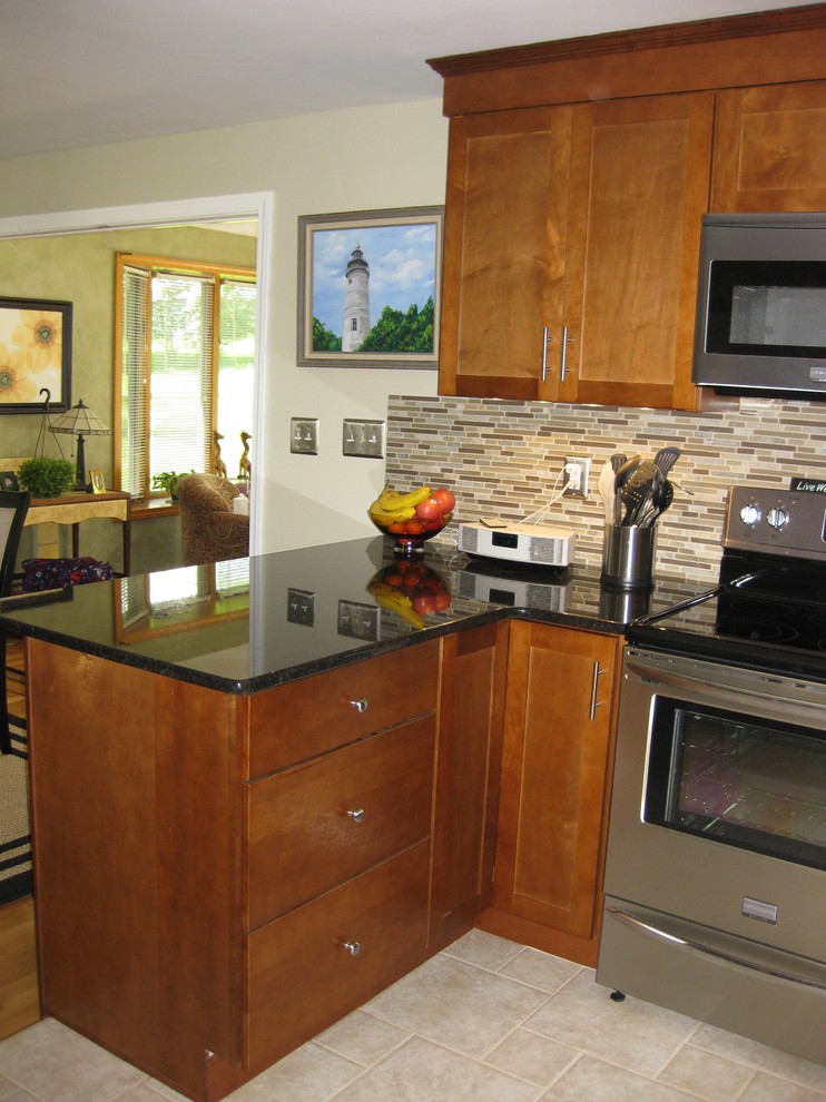 Eat-in kitchen - transitional u-shaped travertine floor and beige floor eat-in kitchen idea in Boston with an undermount sink, medium tone wood cabinets, granite countertops, stainless steel appliances, a peninsula, shaker cabinets, brown backsplash, matchstick tile backsplash and black countertops