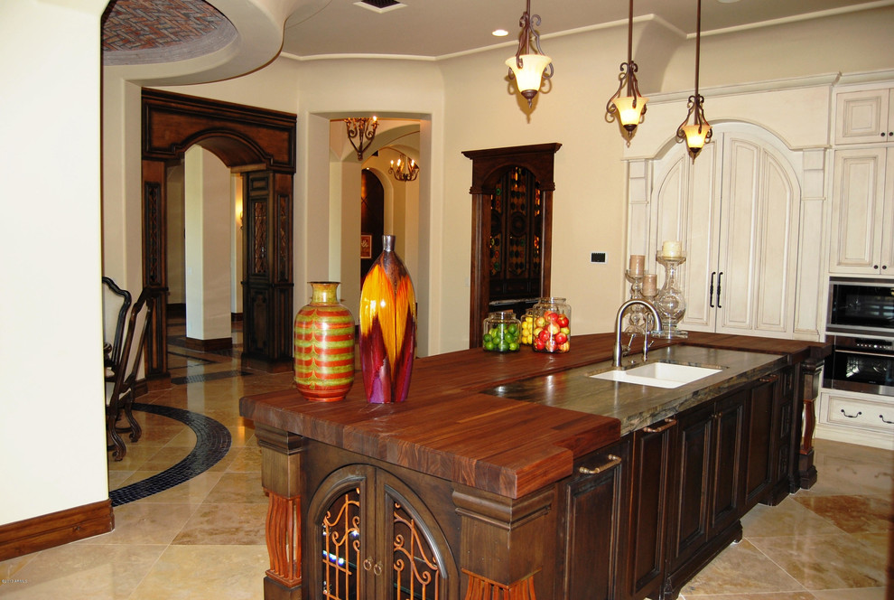 Large transitional l-shaped travertine floor open concept kitchen photo in Phoenix with an undermount sink, raised-panel cabinets, white cabinets, granite countertops, paneled appliances and an island
