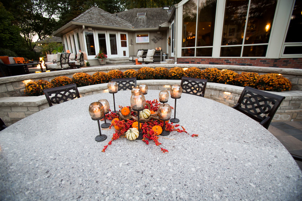 This is an example of a transitional backyard stone water fountain landscape in Omaha.