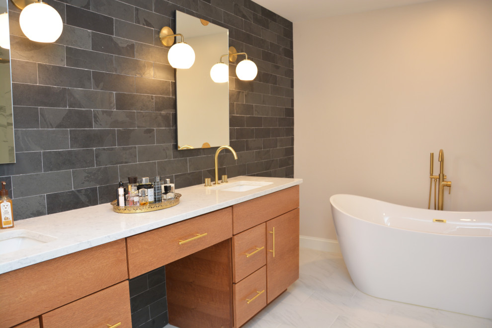 Photo of a large contemporary master bathroom in DC Metro with flat-panel cabinets, light wood cabinets, a freestanding tub, an alcove shower, a two-piece toilet, black tile, slate, grey walls, an undermount sink, engineered quartz benchtops, white floor, white benchtops, a double vanity and a freestanding vanity.