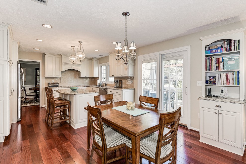 Inspiration for a mid-sized transitional u-shaped medium tone wood floor and brown floor eat-in kitchen remodel in Baltimore with an undermount sink, raised-panel cabinets, white cabinets, granite countertops, beige backsplash, porcelain backsplash, stainless steel appliances and an island