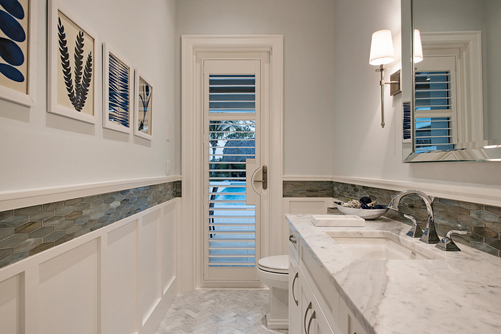 Inspiration for a contemporary powder room in Miami with recessed-panel cabinets and white cabinets.
