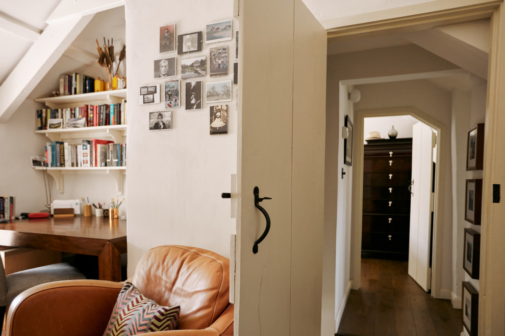 Cette image montre un bureau traditionnel avec un mur blanc, un sol en bois brun, un bureau indépendant et un sol marron.