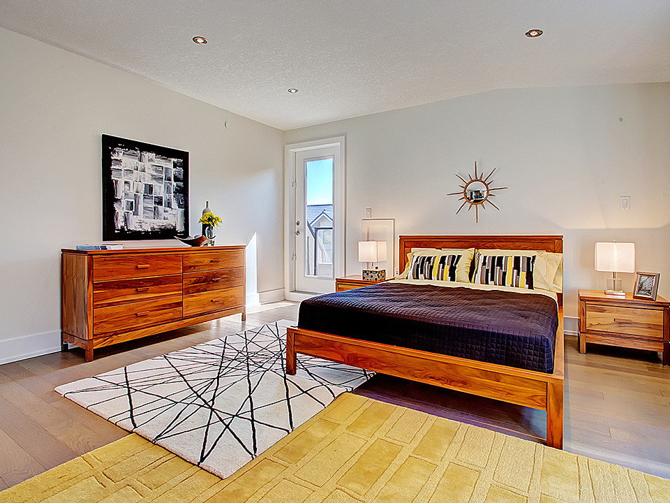 Inspiration for a large scandinavian guest bedroom in Calgary with grey walls, medium hardwood floors and no fireplace.