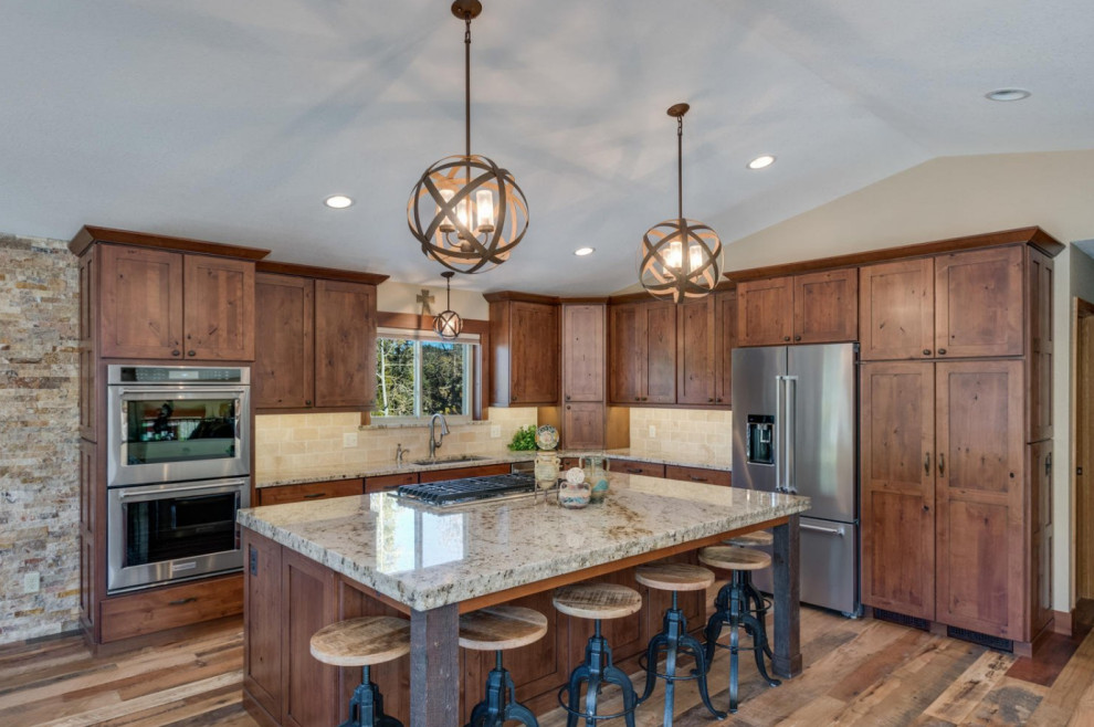 Mid-sized mountain style l-shaped dark wood floor and brown floor eat-in kitchen photo in Denver with an undermount sink, shaker cabinets, dark wood cabinets, granite countertops, beige backsplash, ceramic backsplash, stainless steel appliances, an island and beige countertops