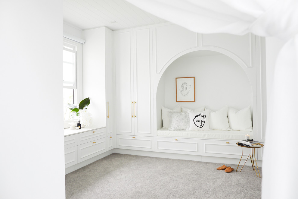 Design ideas for a large beach style gender-neutral walk-in wardrobe in Sydney with white cabinets, carpet, grey floor and recessed-panel cabinets.