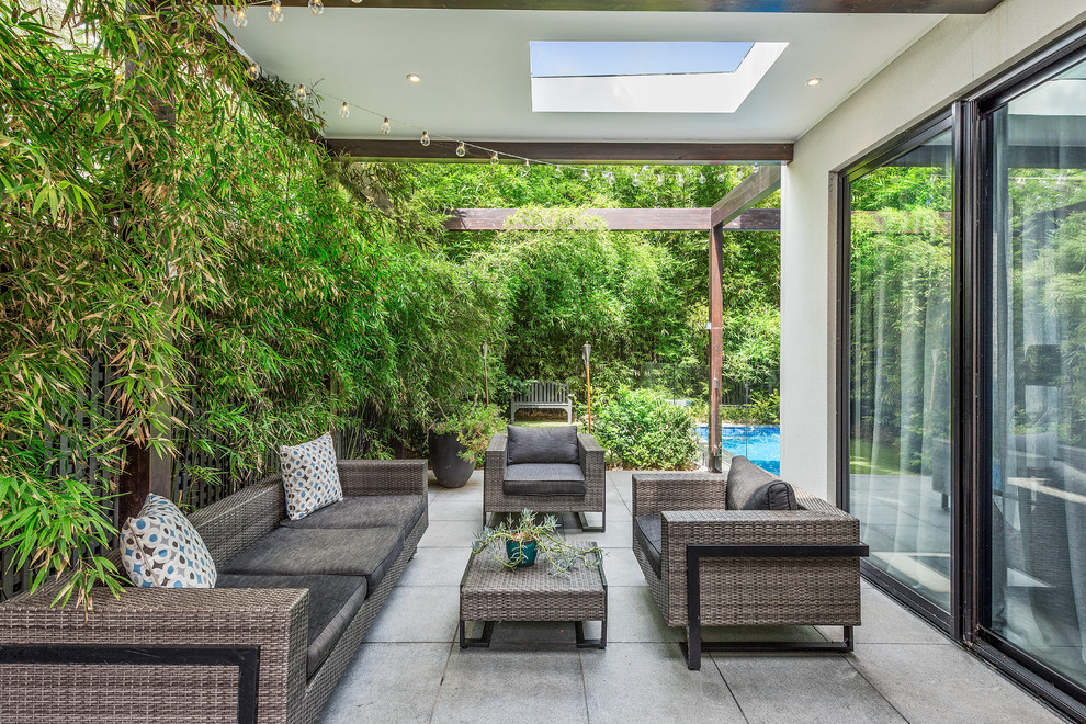 Photo of a contemporary side yard patio in Melbourne with concrete pavers and a roof extension.