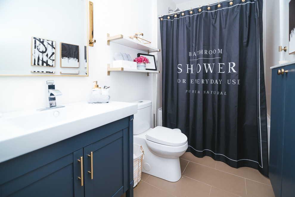 Small modern kids bathroom in Toronto with recessed-panel cabinets, blue cabinets, a drop-in tub, a shower/bathtub combo, a one-piece toilet, white tile, white walls, porcelain floors, an integrated sink, beige floor and a shower curtain.