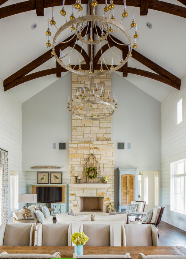 This is an example of a large country formal open concept living room in Austin with white walls, dark hardwood floors, a standard fireplace, a stone fireplace surround and a built-in media wall.