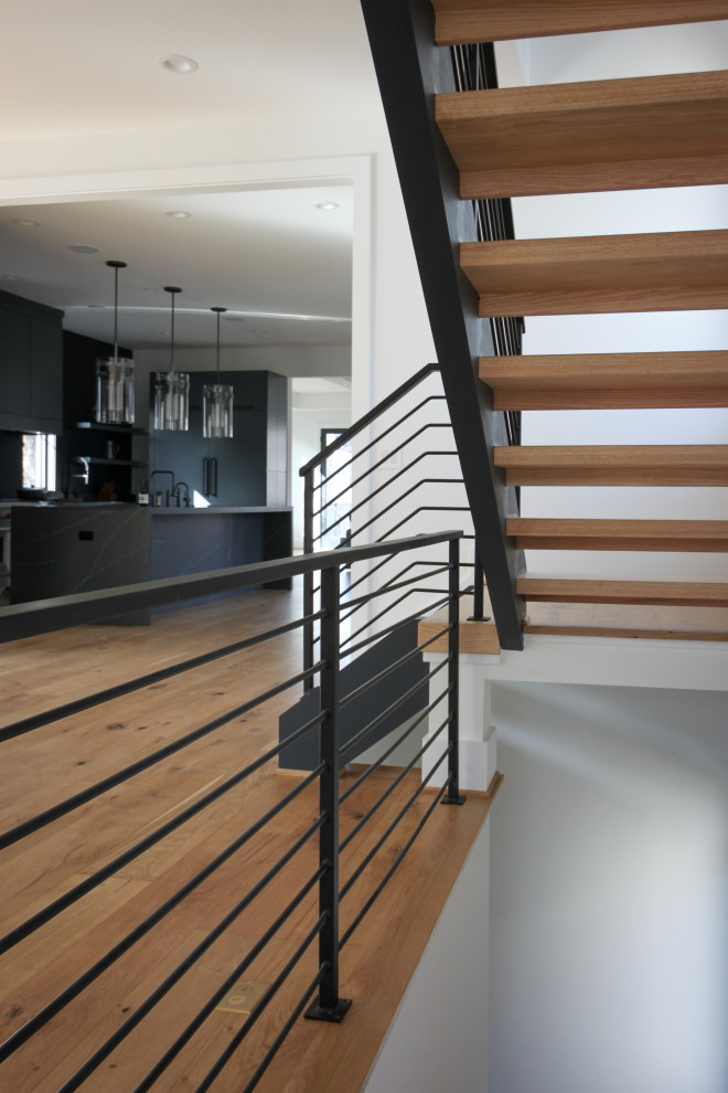 Mid-sized contemporary wood straight staircase in DC Metro with metal railing.