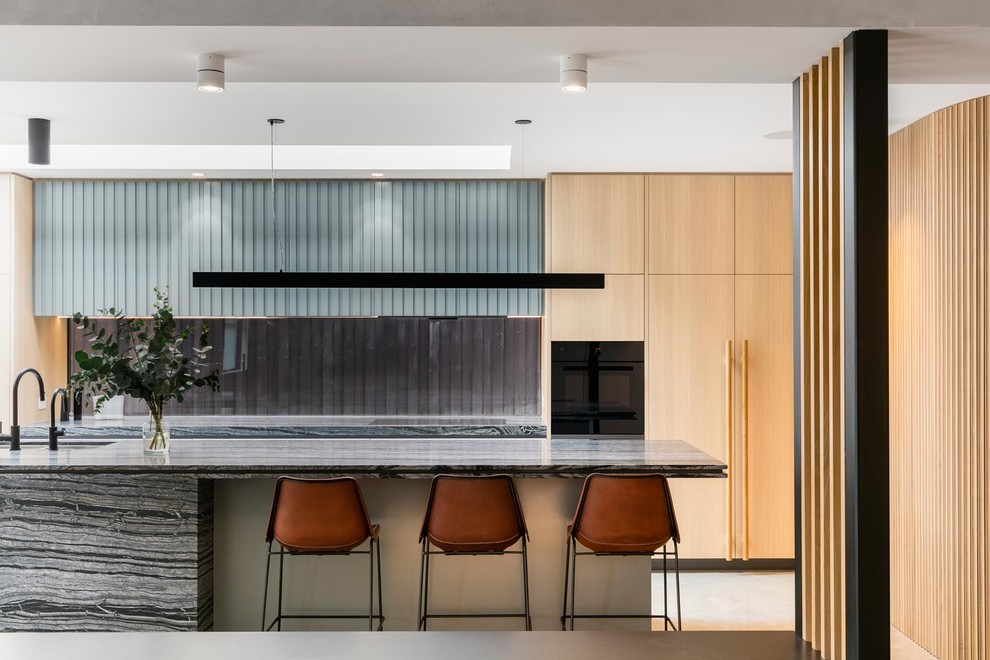 Inspiration for a contemporary galley kitchen in Melbourne with an undermount sink, flat-panel cabinets, light wood cabinets, window splashback, with island and grey benchtop.