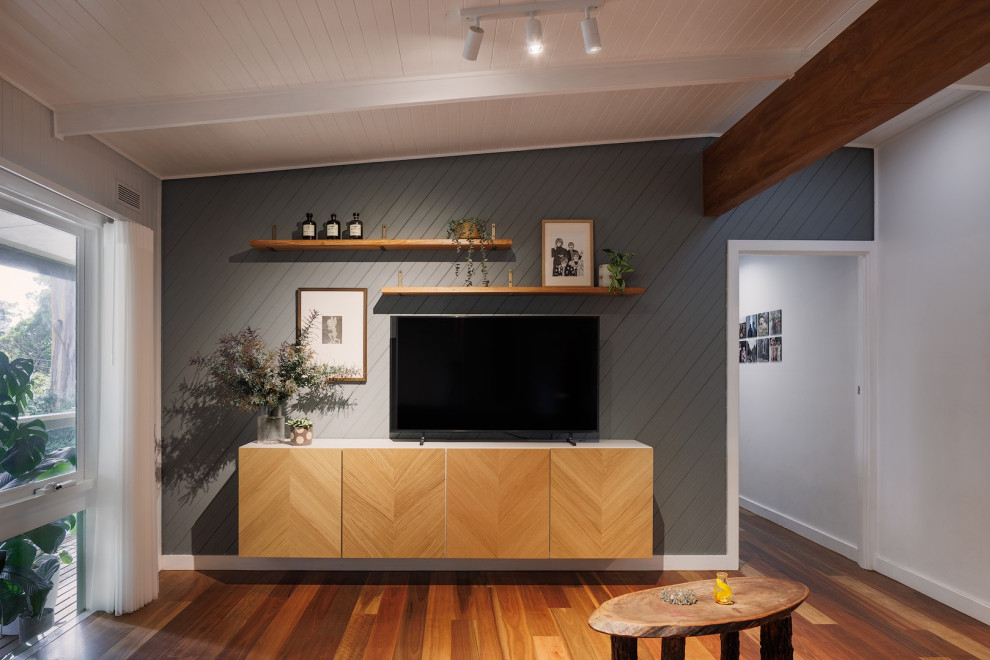 Mittelgroßes, Offenes Modernes Wohnzimmer mit grüner Wandfarbe, braunem Holzboden, TV-Wand, braunem Boden, freigelegten Dachbalken und vertäfelten Wänden in Melbourne
