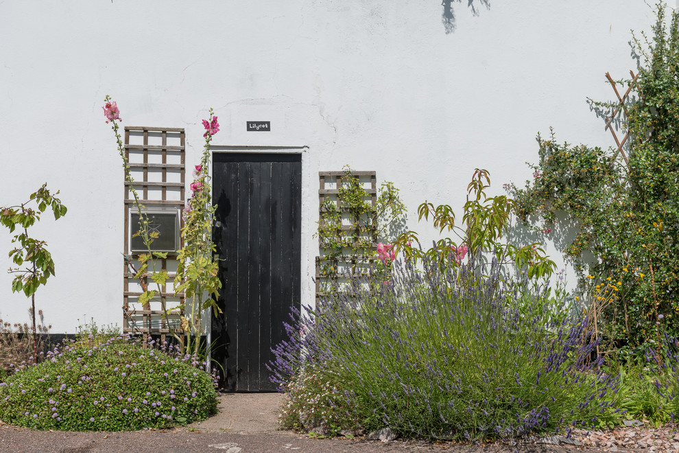 Inspiration for a small eclectic two-storey stucco white exterior in Devon.