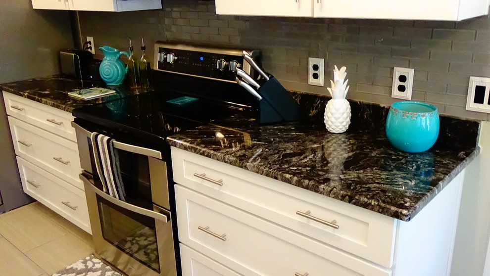 Mid-sized transitional galley porcelain tile and gray floor eat-in kitchen photo in Orlando with a single-bowl sink, shaker cabinets, white cabinets, granite countertops, gray backsplash, subway tile backsplash, stainless steel appliances and no island