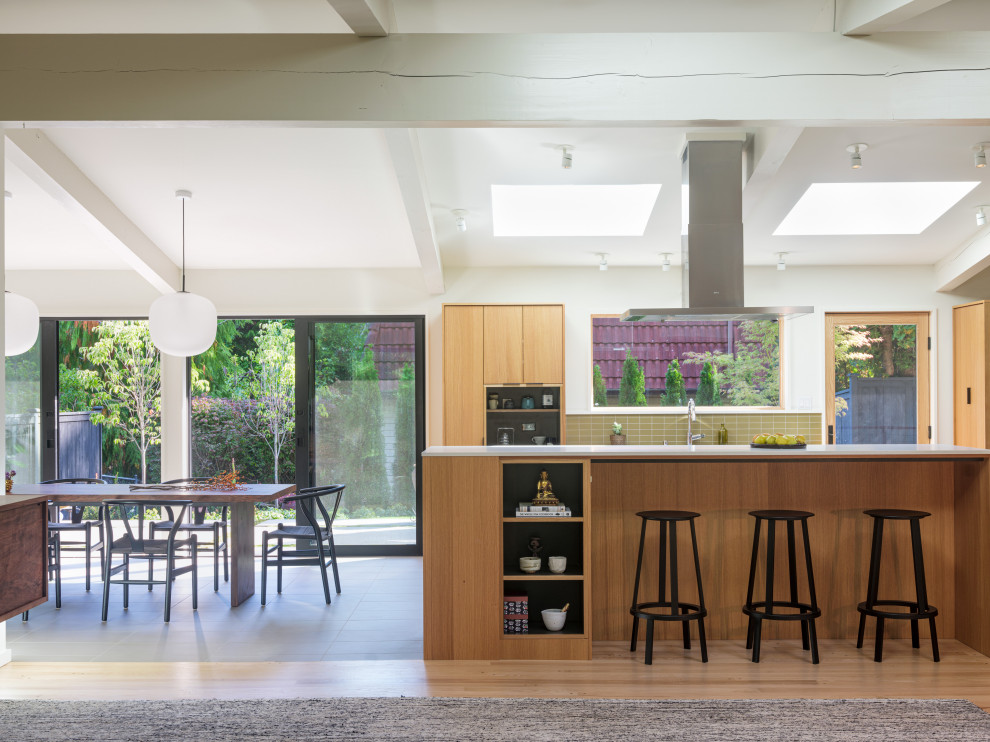 Design ideas for a midcentury kitchen in Seattle with flat-panel cabinets, light wood cabinets, engineered stone countertops, green splashback, ceramic splashback, stainless steel appliances, porcelain flooring, an island, grey floors, grey worktops and exposed beams.