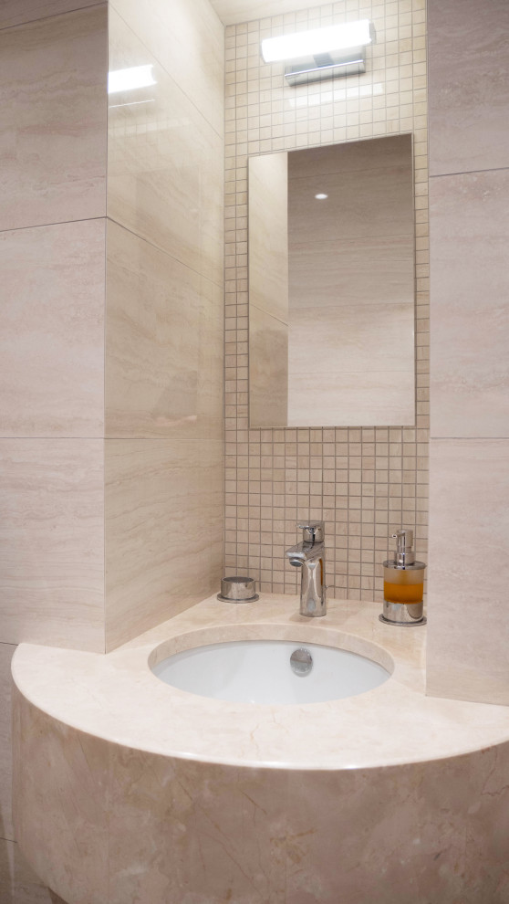 Medium sized contemporary cloakroom in Moscow with a two-piece toilet, beige tiles, ceramic tiles, beige walls, medium hardwood flooring, an integrated sink, solid surface worktops, beige worktops, feature lighting, a built in vanity unit and a drop ceiling.