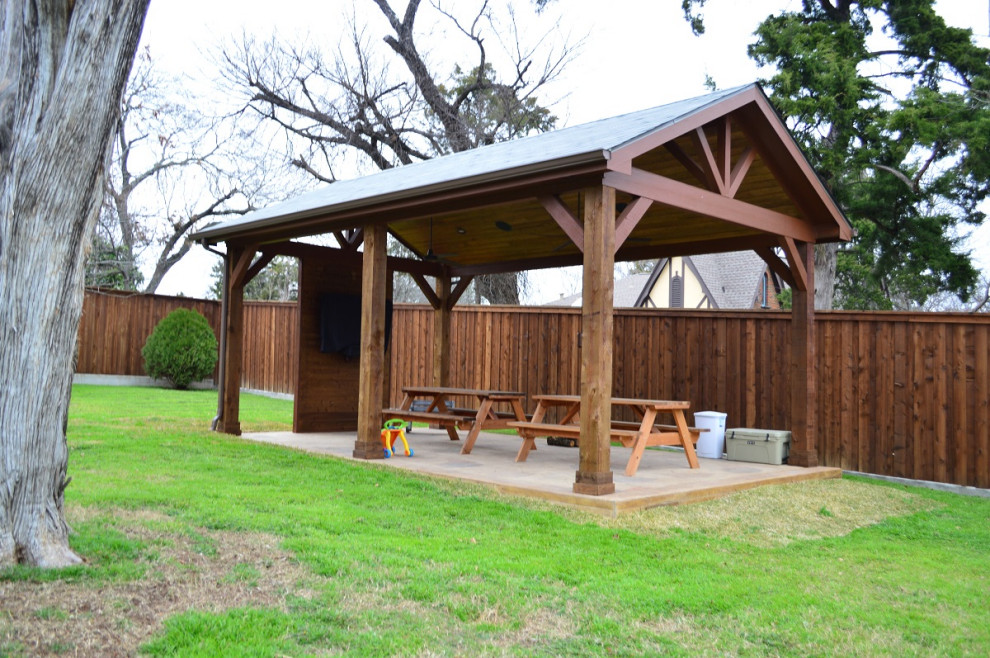 This is an example of a large country backyard verandah in Dallas with with columns and stamped concrete.