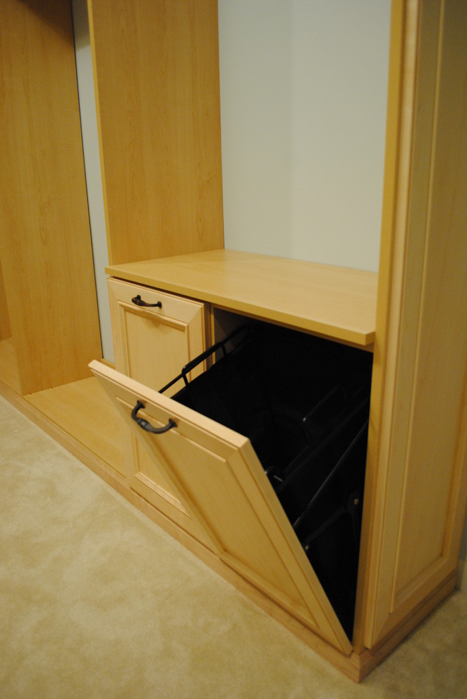 This is an example of a large transitional gender-neutral walk-in wardrobe in DC Metro with recessed-panel cabinets, light wood cabinets and carpet.