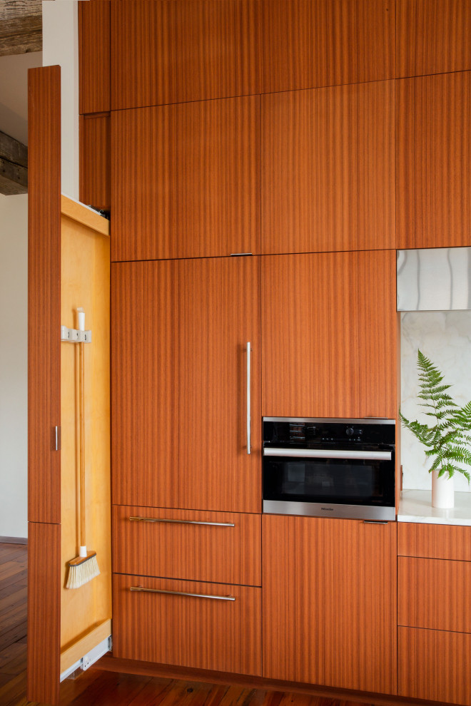 Inspiration for a large kitchen remodel with flat-panel cabinets, medium tone wood cabinets, granite countertops, gray backsplash, marble backsplash, an island and white countertops