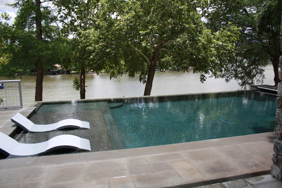 Mid-sized modern backyard rectangular infinity pool in Austin with a hot tub and tile.
