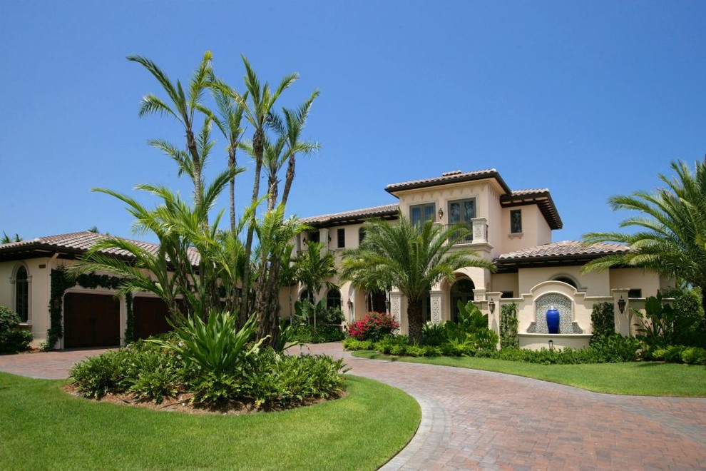This is an example of a mediterranean two-storey stucco yellow exterior in Miami.