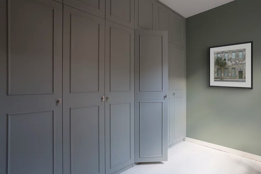 Cette image montre une grande chambre parentale grise et blanche design avec un mur vert, parquet peint et un sol blanc.
