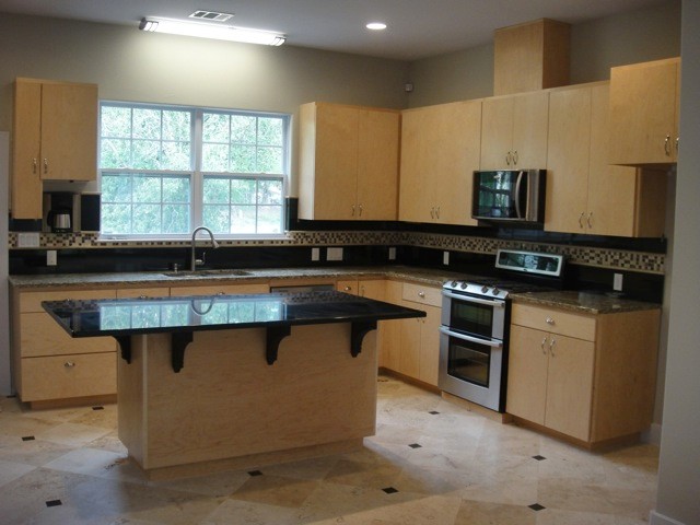 Eat-in kitchen - mid-sized modern l-shaped medium tone wood floor and gray floor eat-in kitchen idea in Austin with flat-panel cabinets, light wood cabinets, granite countertops, black backsplash, ceramic backsplash, stainless steel appliances, an island and multicolored countertops