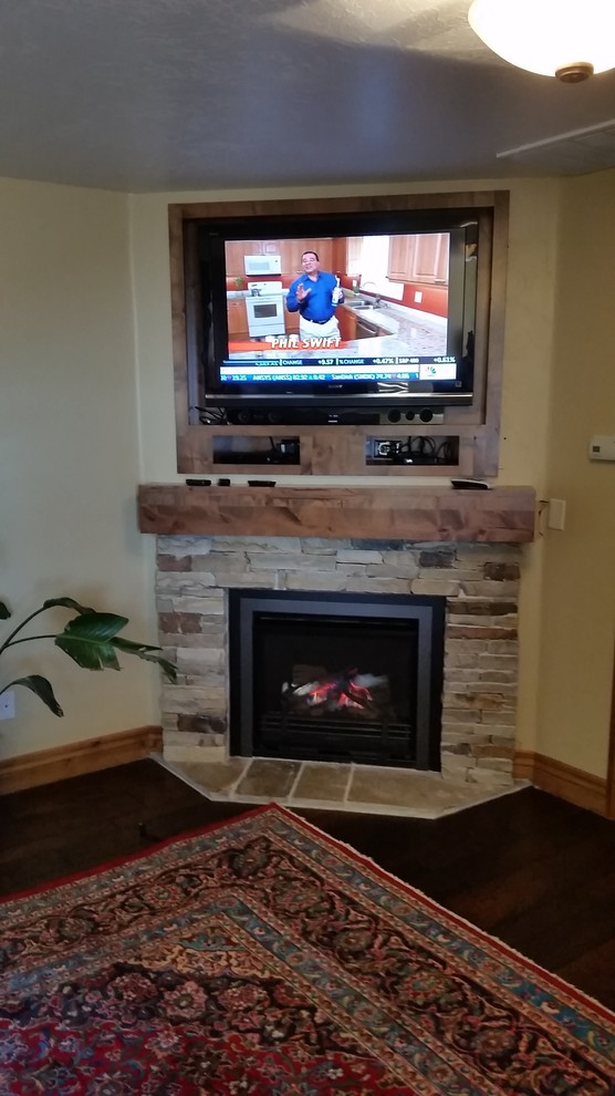 This is an example of a mid-sized traditional formal enclosed living room in Salt Lake City with beige walls, dark hardwood floors, a corner fireplace, a stone fireplace surround, a wall-mounted tv and brown floor.