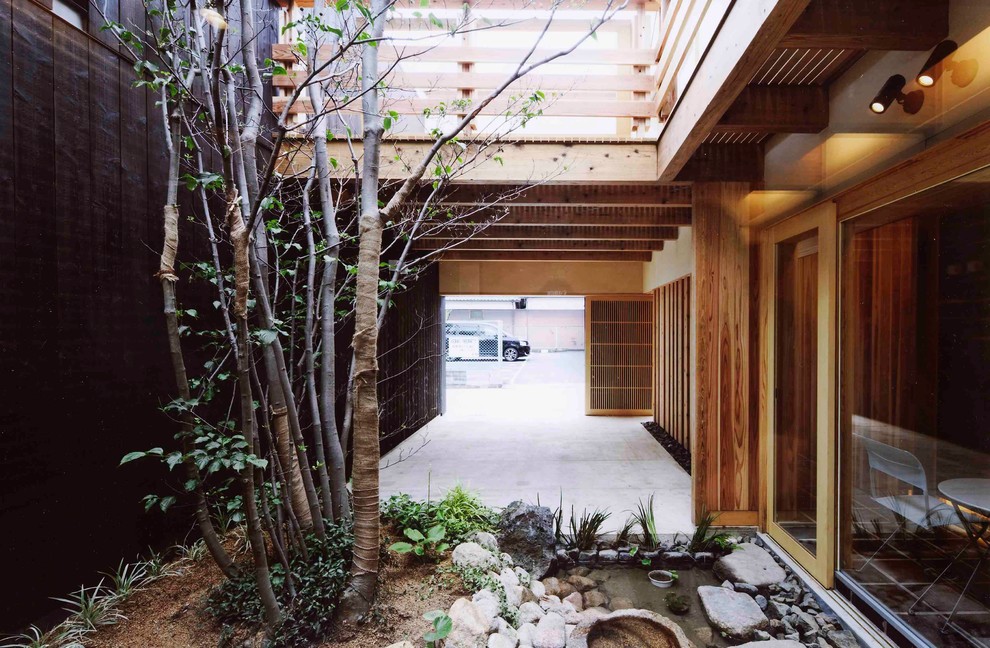 Photo of an asian courtyard partial sun driveway in Other with a container garden.