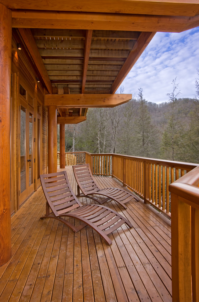 Photo of a large arts and crafts backyard deck in Other with a roof extension.