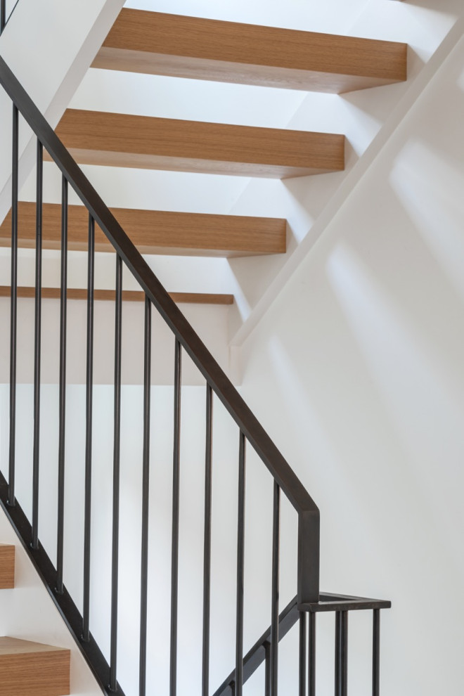 Design ideas for a large transitional wood u-shaped staircase in Toronto with wood risers and metal railing.