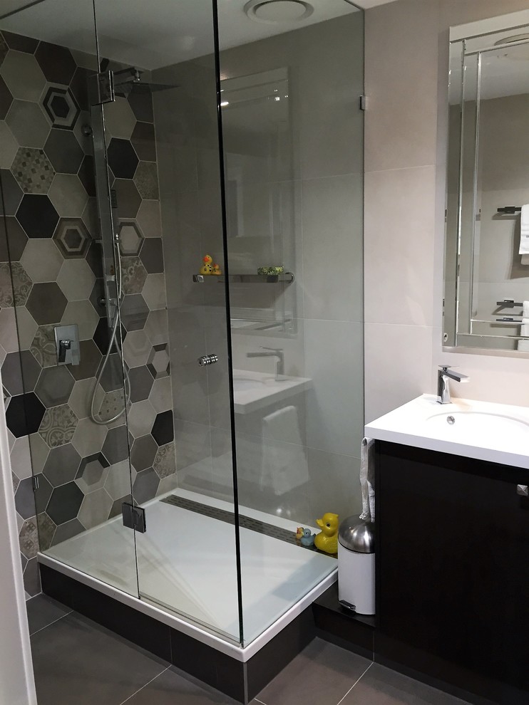 Photo of a mid-sized transitional kids bathroom in Melbourne with furniture-like cabinets, brown cabinets, a double shower, a two-piece toilet, beige tile, porcelain tile, multi-coloured walls, porcelain floors, an undermount sink and engineered quartz benchtops.