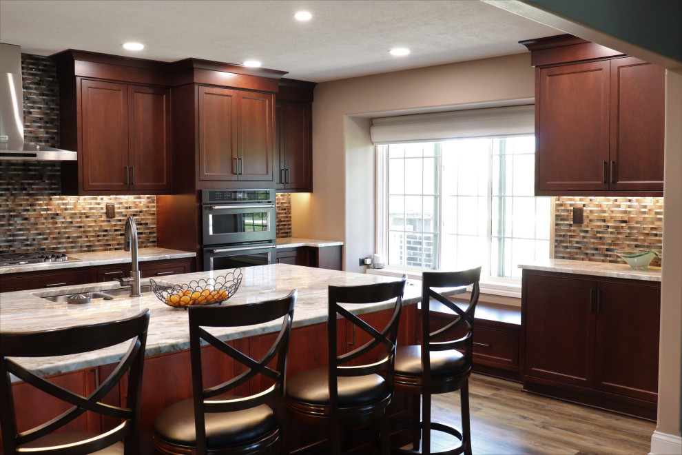 Inspiration for a large transitional l-shaped enclosed kitchen remodel with an undermount sink, beaded inset cabinets, granite countertops, multicolored backsplash, an island and beige countertops