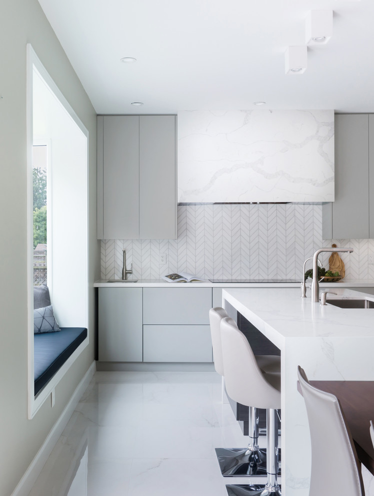 Photo of a mid-sized modern l-shaped eat-in kitchen in Toronto with an undermount sink, flat-panel cabinets, grey cabinets, quartz benchtops, white splashback, porcelain splashback, stainless steel appliances, porcelain floors, with island, white floor and white benchtop.