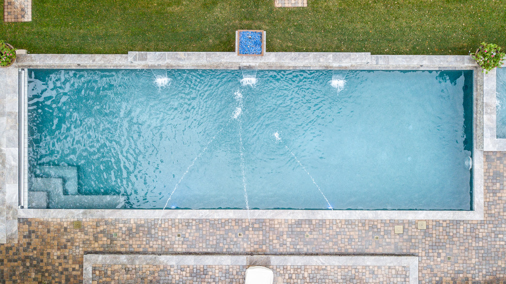 Photo of a large mediterranean backyard rectangular pool in Houston with a pool house and concrete pavers.