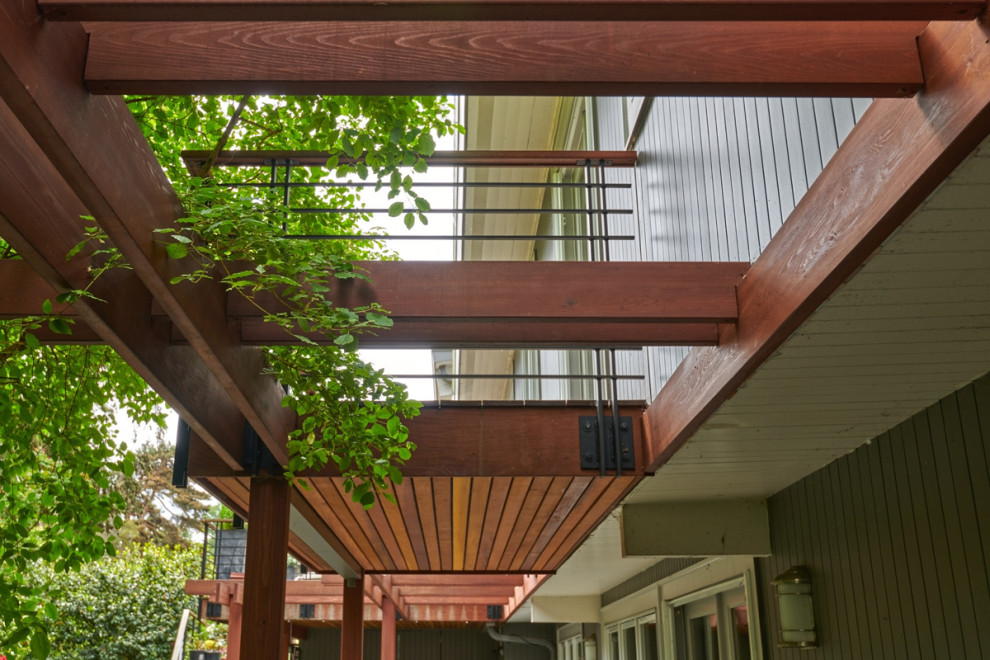 Idée de décoration pour une façade de maison vintage en bois à niveaux décalés avec un toit à deux pans et un toit en métal.