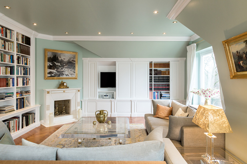 Große, Abgetrennte Klassische Bibliothek mit verstecktem TV, grüner Wandfarbe, braunem Holzboden, Kamin, verputzter Kaminumrandung und braunem Boden in Hamburg