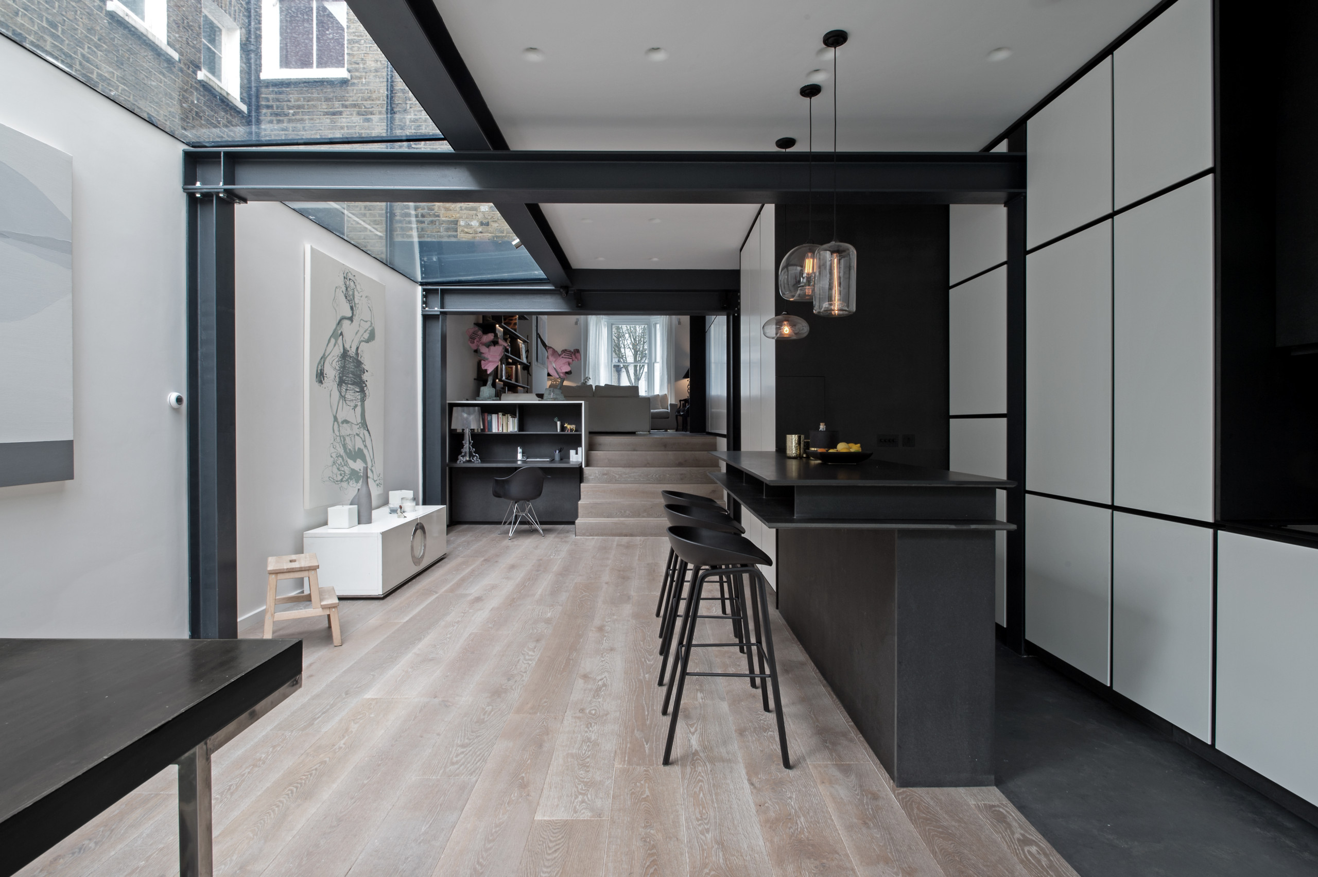 Minimalist modern black & white kitchen with black recess handles for edginess and sharp look. We've capitalised on black architectural steel beams to maximise height and glass/sun. the chosen style o