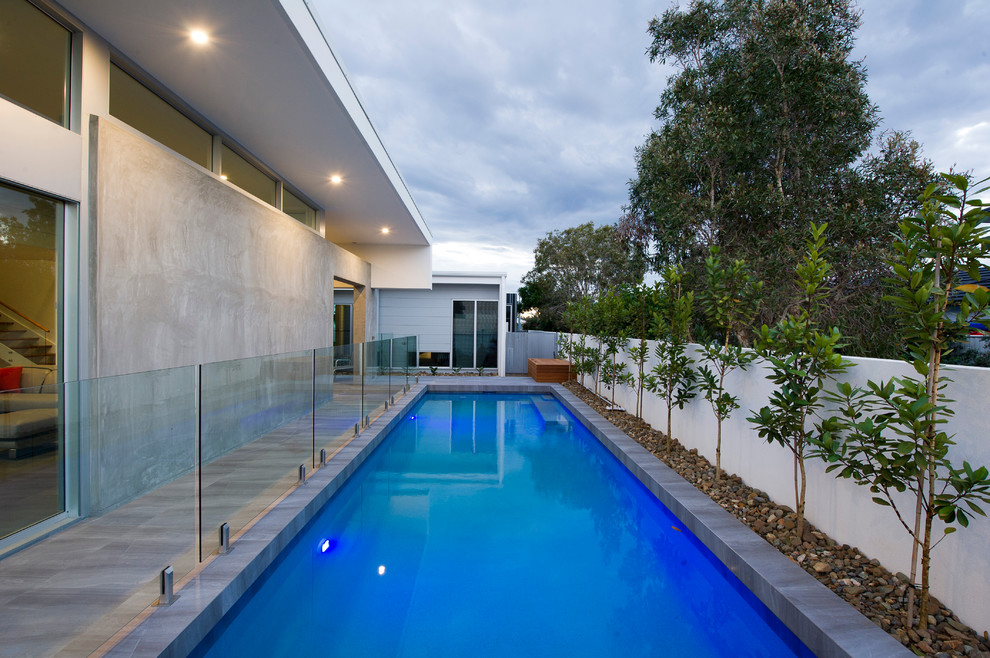 Design ideas for a large contemporary backyard rectangular pool in Sunshine Coast with natural stone pavers.