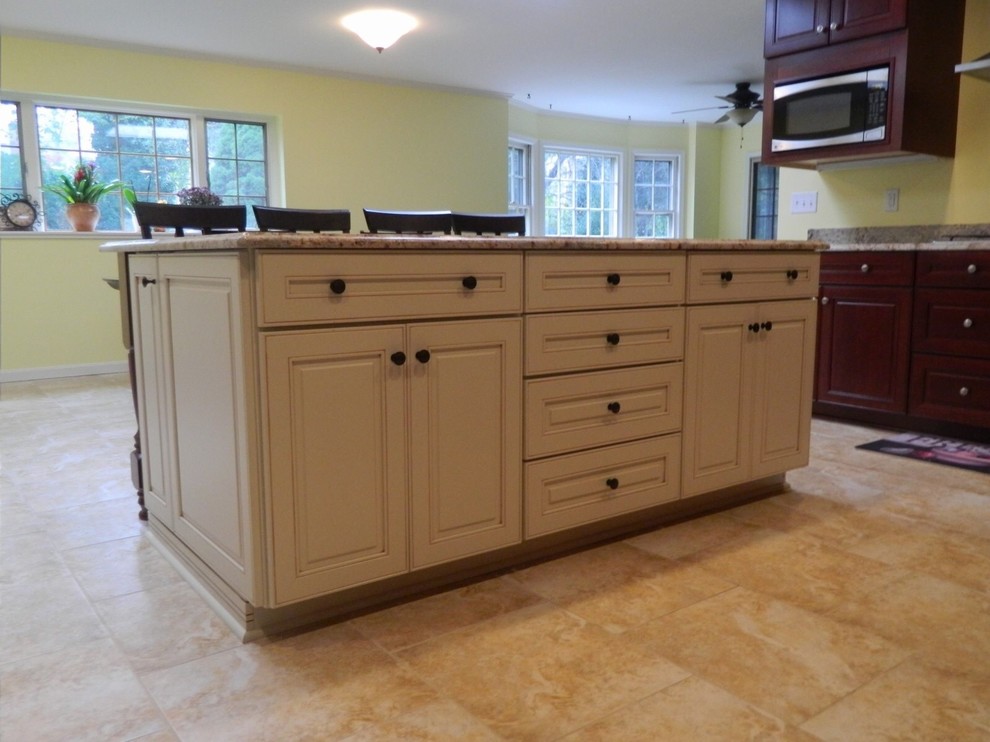 Photo of a large traditional u-shaped open plan kitchen in DC Metro with an undermount sink, raised-panel cabinets, dark wood cabinets, granite benchtops, stone slab splashback, stainless steel appliances, ceramic floors and with island.