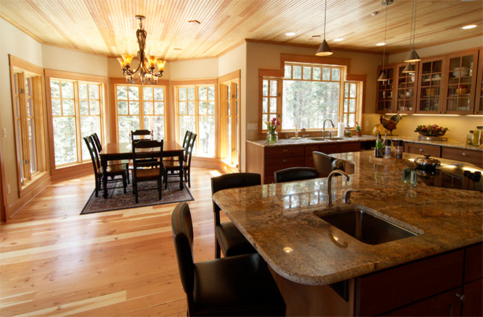 Example of a large mountain style medium tone wood floor eat-in kitchen design in Denver with an undermount sink, shaker cabinets, brown cabinets, granite countertops, stainless steel appliances and an island