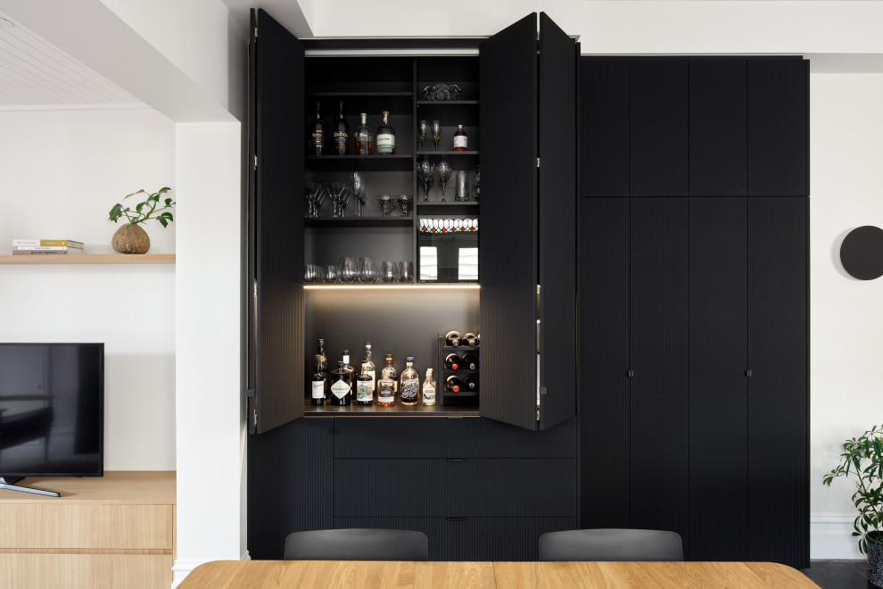 Design ideas for a medium sized contemporary home bar in Melbourne with flat-panel cabinets, ceramic splashback, slate flooring and black floors.