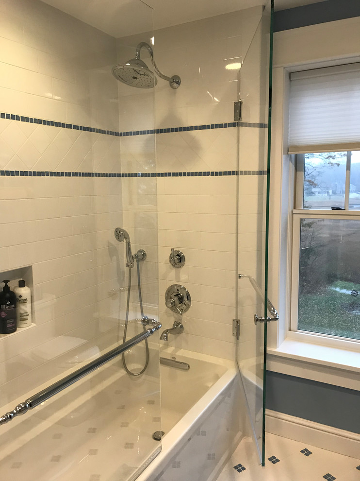 Photo of a small traditional master bathroom in Bridgeport with furniture-like cabinets, white cabinets, an alcove tub, a shower/bathtub combo, a one-piece toilet, white tile, grey walls, ceramic floors, an undermount sink, granite benchtops, white floor and a hinged shower door.