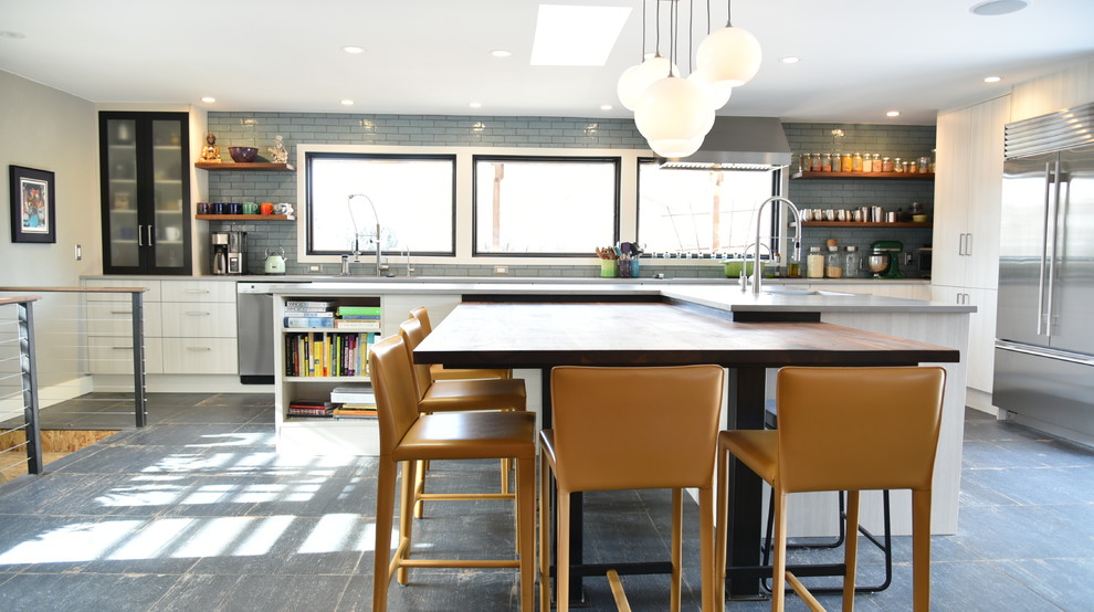 Inspiration for a large industrial l-shaped eat-in kitchen in Denver with a single-bowl sink, flat-panel cabinets, beige cabinets, quartzite benchtops, blue splashback, brick splashback, stainless steel appliances, porcelain floors, with island and grey floor.