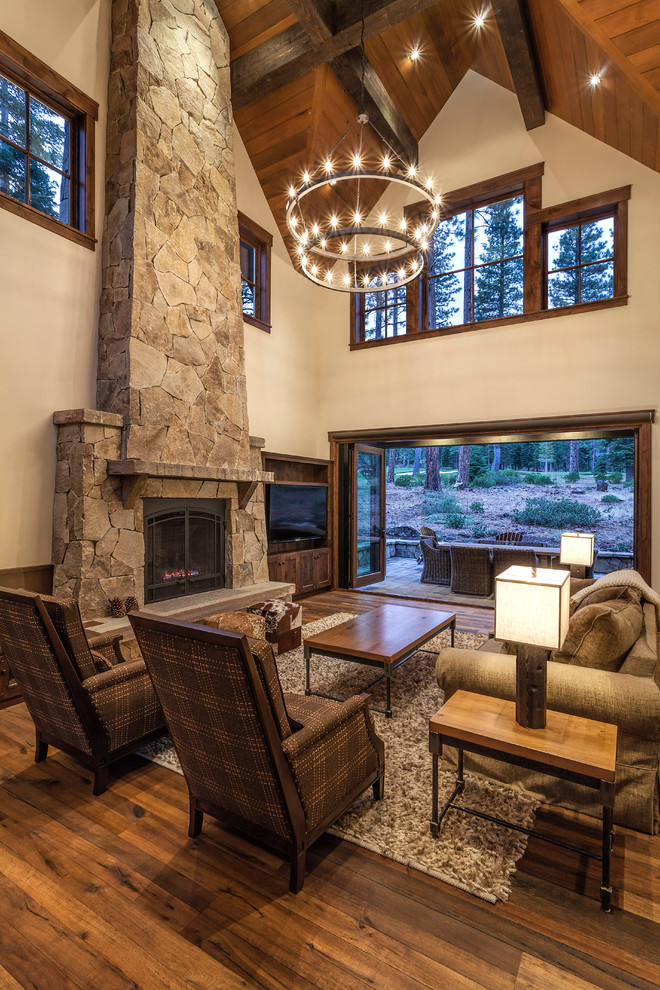 This is an example of a country formal living room in Sacramento with beige walls, dark hardwood floors, a standard fireplace, a stone fireplace surround and a built-in media wall.