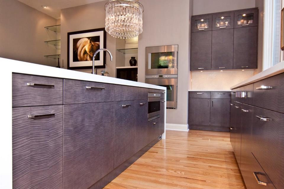 Inspiration for a mid-sized modern l-shaped kitchen pantry in Houston with flat-panel cabinets, medium wood cabinets, laminate benchtops, white splashback, stainless steel appliances, light hardwood floors and with island.