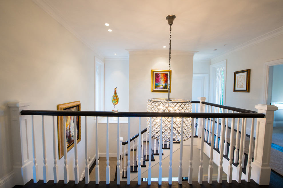 This is an example of a large contemporary carpeted l-shaped staircase in Sunshine Coast with carpet risers and wood railing.