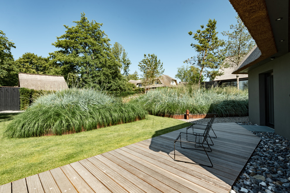 Diseño de terraza campestre de tamaño medio sin cubierta en patio lateral con barandilla de madera