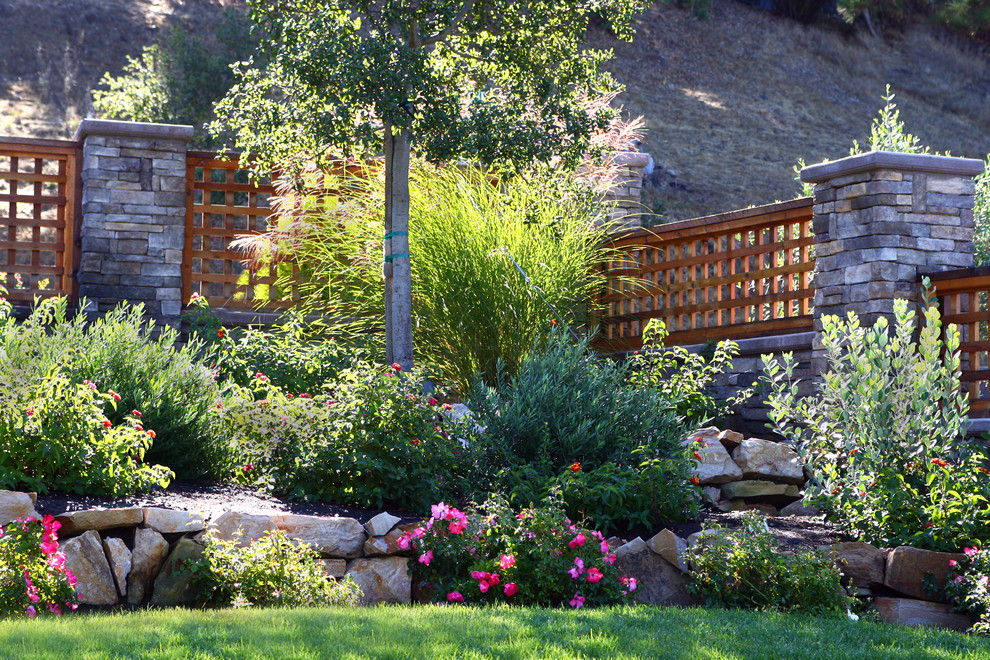 Photo of an expansive arts and crafts front yard partial sun garden in San Francisco with a retaining wall, natural stone pavers and a stone fence.